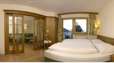 a bedroom with two white beds and a window at Residence Villa Funtanes in Selva di Val Gardena