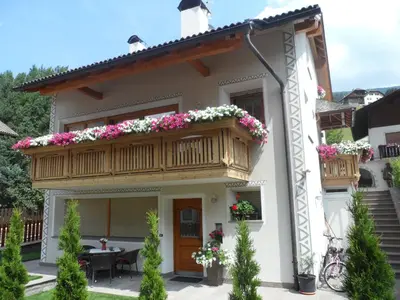 a house with a balcony with flowers on it at Cesa Sule de Sot in Ortisei