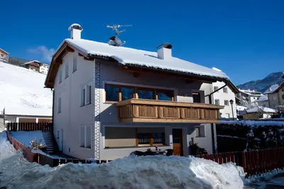 a house with a balcony in the snow at Cesa Sule de Sot in Ortisei