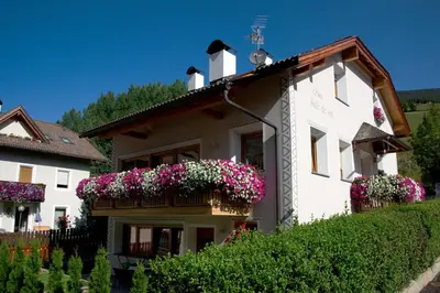 a white house with flower boxes on it at Cesa Sule de Sot in Ortisei