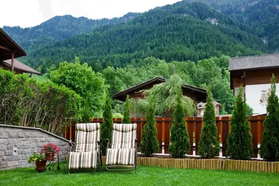 two chairs in a yard with mountains in the background at Cesa Sule de Sot in Ortisei