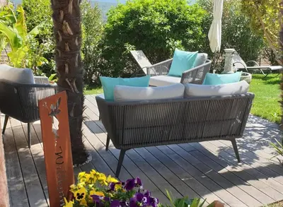 a patio with chairs and pillows on a deck at Ansitz Strengherrnhof in Caldaro
