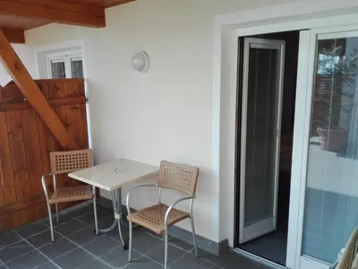 a table and chairs on the porch of a house at Hotel Haselried in Tirolo