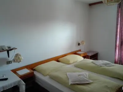 a bedroom with two beds and a table and a window at Hotel Haselried in Tirolo