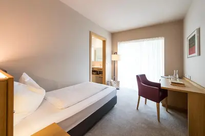 a hotel room with a bed and a desk at Hotel CampingPark Steiner in Laives