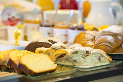 a table topped with different types of bread and pastries at Hotel CampingPark Steiner in Laives