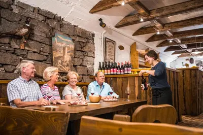 a group of people sitting at a table in a restaurant at Hotel CampingPark Steiner in Laives