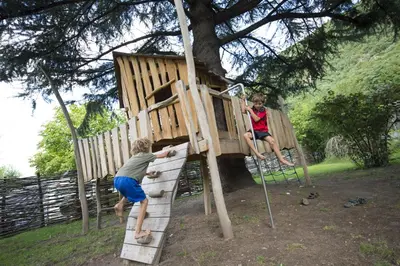 two young boys playing in a tree house at Hotel CampingPark Steiner in Laives