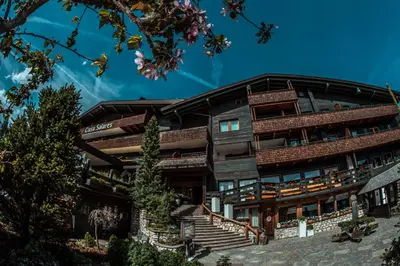 a large building with stairs in front of it at Hotel Ciasa Salares in San Cassiano