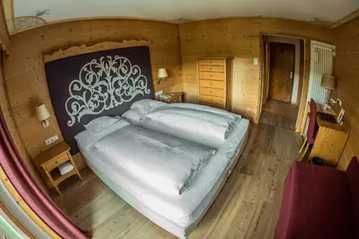 a bedroom with a large bed in a room at Hotel Ciasa Salares in San Cassiano