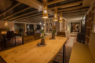 a large room with a wooden table and chairs at Hotel Ciasa Salares in San Cassiano