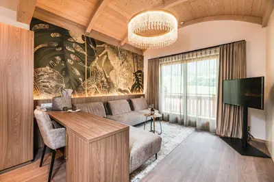 a living room with a couch and a tv at Hotel Weingarten in Appiano sulla Strada del Vino