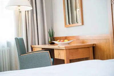 a room with a table with a bowl of fruit on it at HOTEL POST alpine cityflair in Brunico