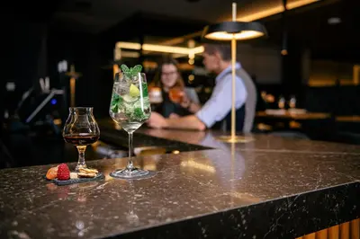 a counter with two glasses of wine and strawberries on it at HOTEL POST alpine cityflair in Brunico