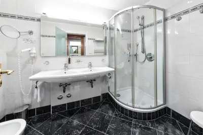 a bathroom with a sink and a shower at HOTEL POST alpine cityflair in Brunico
