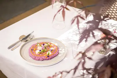 a table with a plate of food on a table at HOTEL POST alpine cityflair in Brunico