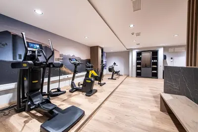 a gym with treadmills and ellipticals in a room at HOTEL POST alpine cityflair in Brunico