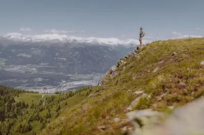 a person standing on the side of a mountain at HOTEL POST alpine cityflair in Brunico