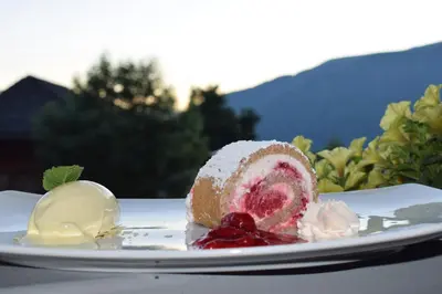 a piece of cake on a plate with ice cream at Naturhotel Miraval in Perca