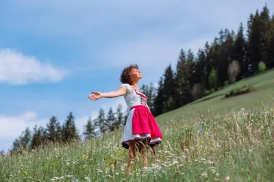 a woman in a pink dress standing in a field at Naturhotel Miraval in Perca