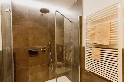 a bathroom with a shower with a glass door at Naturhotel Miraval in Perca
