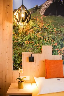 a bedroom with a bed with a painting of a field of flowers at Naturhotel Miraval in Perca