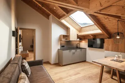 a living room with a couch and a table and a kitchen at Apartment Lodge Gasserhof in Bressanone