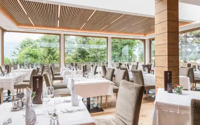 a restaurant with white tables and chairs and windows at Apartment Lodge Gasserhof in Bressanone