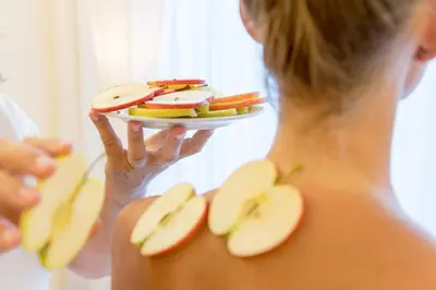 a woman holding a plate of apple slices at Hotel Wiesenhof in Lagundo