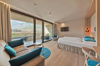 a hotel room with a bed and a large window at Hotel Wiesenhof in Lagundo