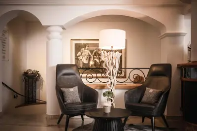 a bar in a restaurant with couches and tables at Alpenheim Charming & Spa Hotel in Ortisei