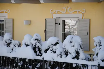 a house with snow on the fence at Dolasilla Park Hotel in Vigo di Fassa