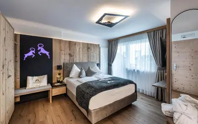 a bedroom with a large bed in a room at ABINEA Dolomiti Romantic SPA in Castelrotto