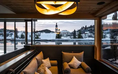 a room with a bench and a window with a view at ABINEA Dolomiti Romantic SPA in Castelrotto