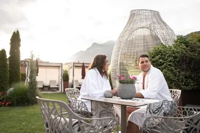 a man and two women sitting at a table at ABINEA Dolomiti Romantic SPA in Castelrotto