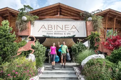 people walking up the stairs to the entrance to a disneyland resort at ABINEA Dolomiti Romantic SPA in Castelrotto