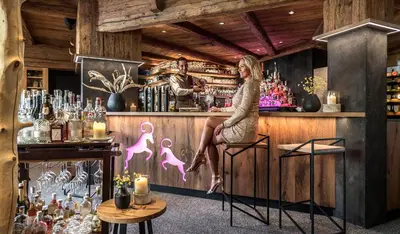 a woman sitting at a bar at ABINEA Dolomiti Romantic SPA in Castelrotto