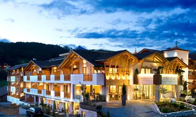 a large building with a lot of lights on at ABINEA Dolomiti Romantic SPA in Castelrotto