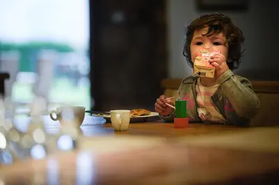 a young child sitting at a table eating food at Miraval Hotel in Coredo
