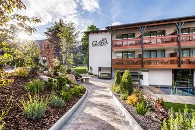 a building with a garden in front of it at Hotel Clara in Bressanone