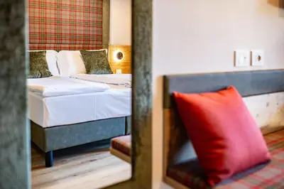 a bedroom with a bed with a red pillow at Hotel Nigritella in Selva di Cadore
