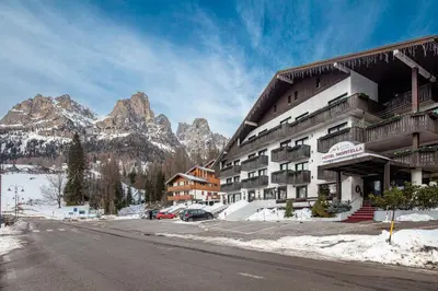 a hotel in the mountains with snow on the ground at Hotel Nigritella in Selva di Cadore