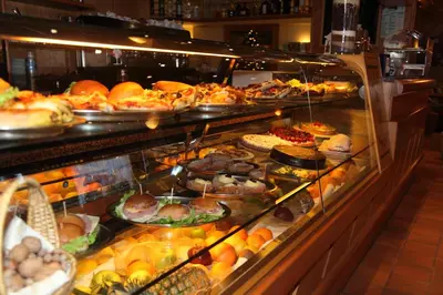 a display case filled with lots of different types of food at Hotel Nigritella in Selva di Cadore
