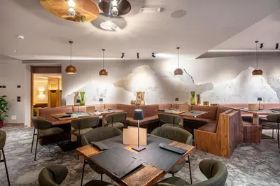 a restaurant with tables and chairs in a room at Hotel Nigritella in Selva di Cadore