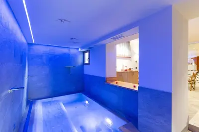 a blue bathroom with a tub in the middle at Relais San Giusto in Campitello di Fassa
