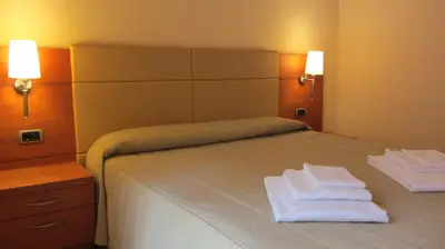 a bedroom with a bed with two towels on it at Relais San Giusto in Campitello di Fassa