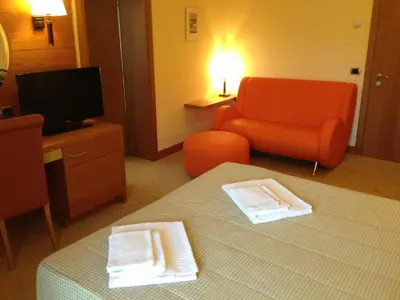 a living room with an orange couch and a chair at Relais San Giusto in Campitello di Fassa