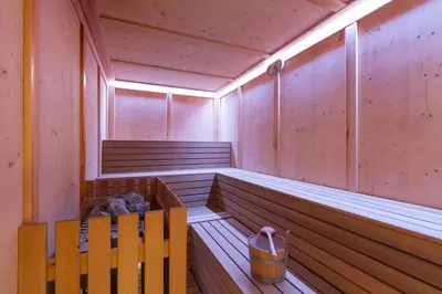 a sauna with two benches and a bucket in it at Relais San Giusto in Campitello di Fassa