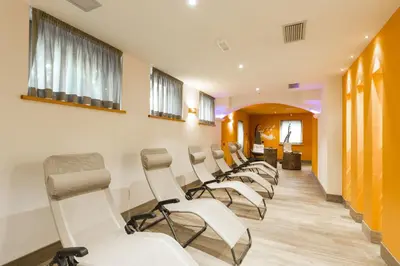 a row of white chairs in a waiting room at Relais San Giusto in Campitello di Fassa