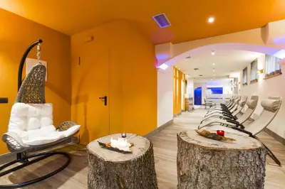 a room with two tree stools and a room with yellow walls at Relais San Giusto in Campitello di Fassa